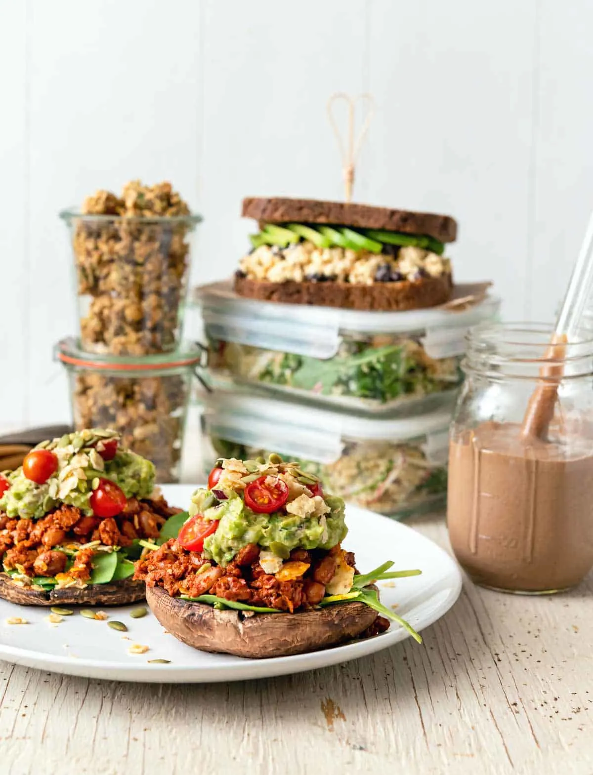 Image of multiple dishes for a High-Protein Vegan Meal Prep for two menu, with stuffed mushrooms in the foreground