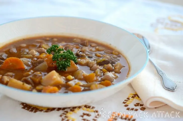Smoky mushroom vegetable soup in a large bowl, topped with parsley