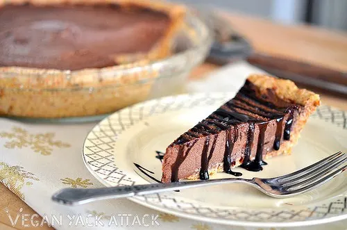 Slice of Raw Chocolate Mousse Pie with Chocolate Drizzle on a plate with fork