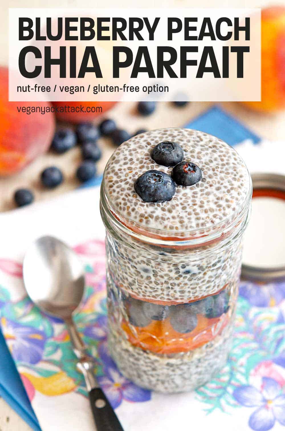 Blueberry peach chia parfait in a glass jar on a floral linen