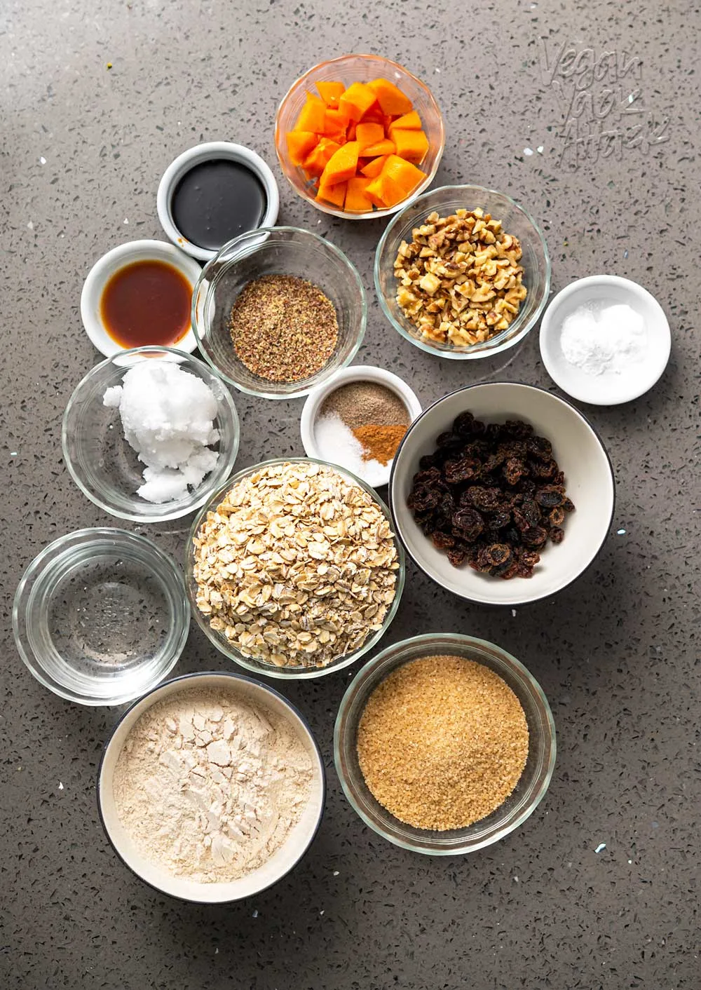 Many small bowls of ingredients for persimmon oatmeal cookies
