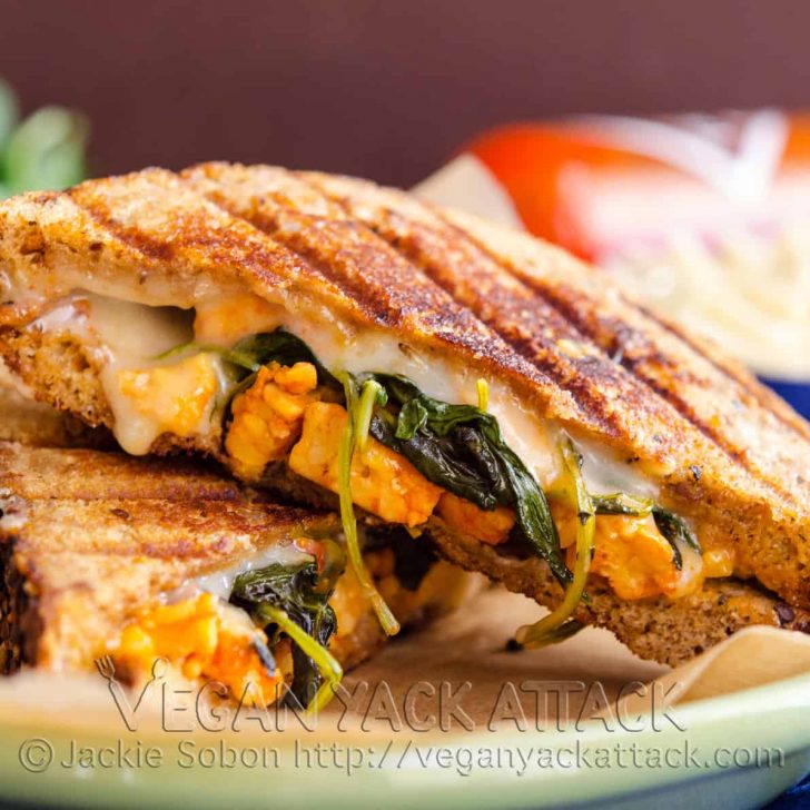 two halves of buffalo tempeh grilled cheese on a green plate