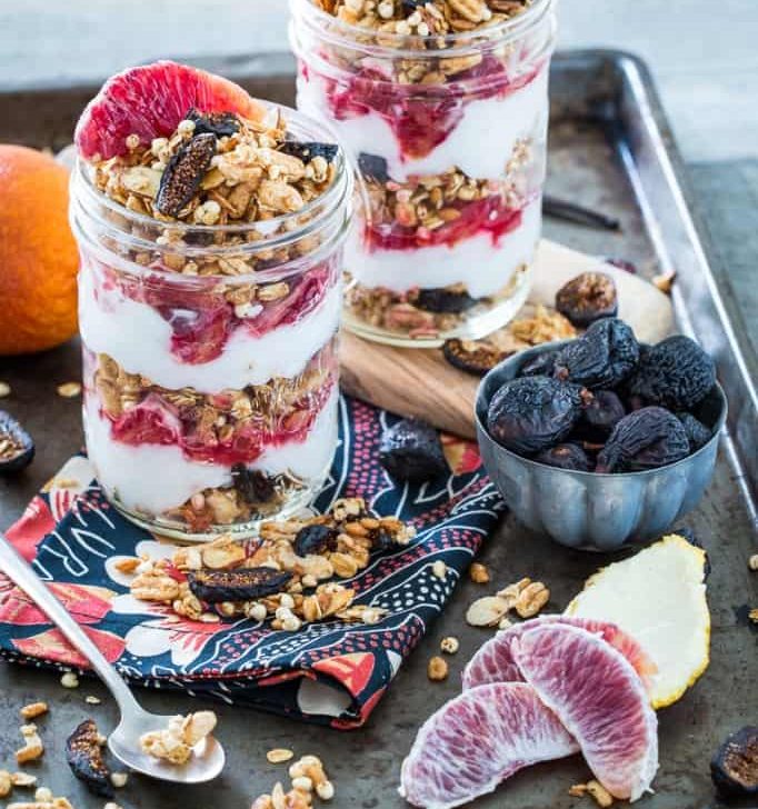 Vanilla Almond Fig Granola Parfaits with Blood Oranges in two jars on a baking sheet