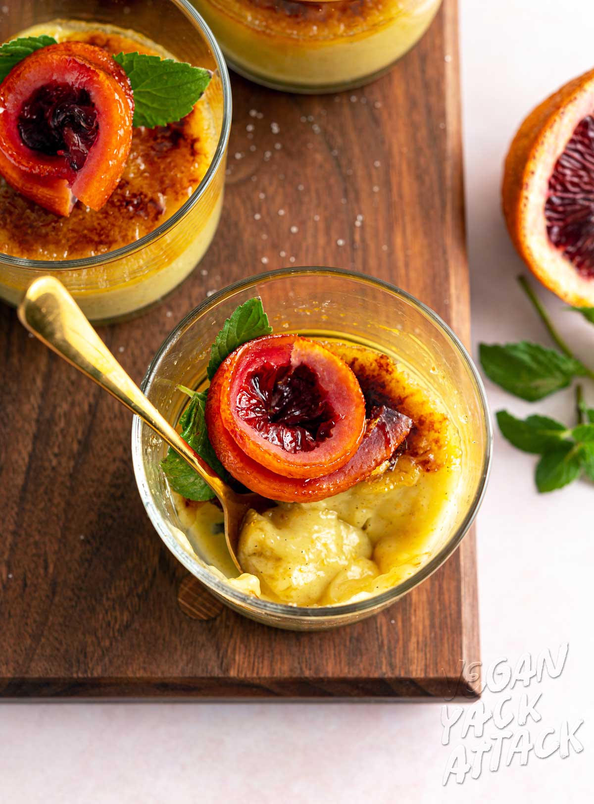 Image of spoon scooping out vegan creme brûlée on a wood board