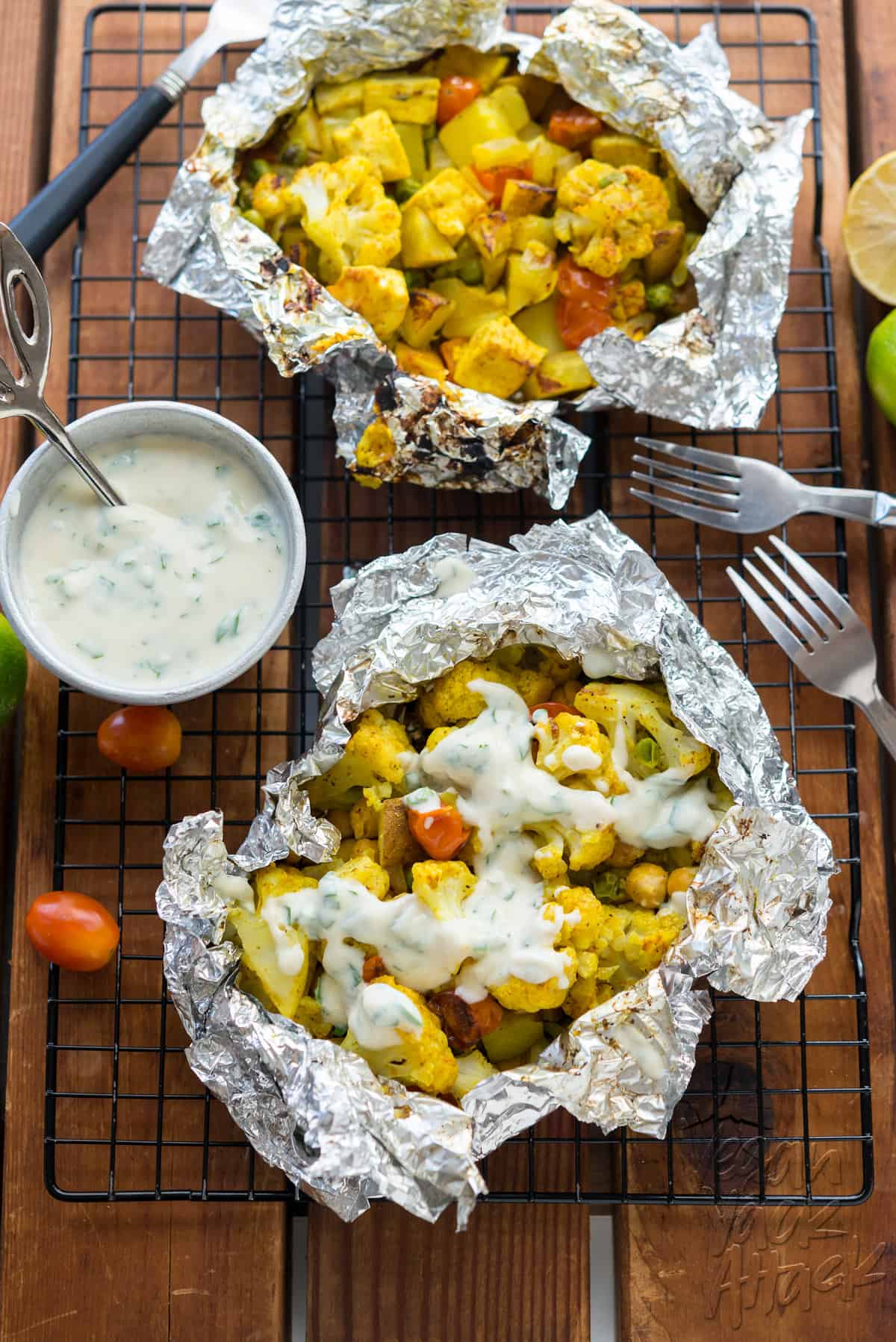 Grill packet filled with curry cauliflower veggie mixture topped with yogurt sauce