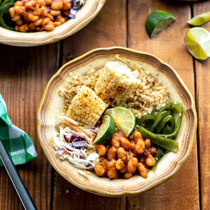 Bowl of summer-time foods including grilled corn, bbq beans, slaw, and quinoa