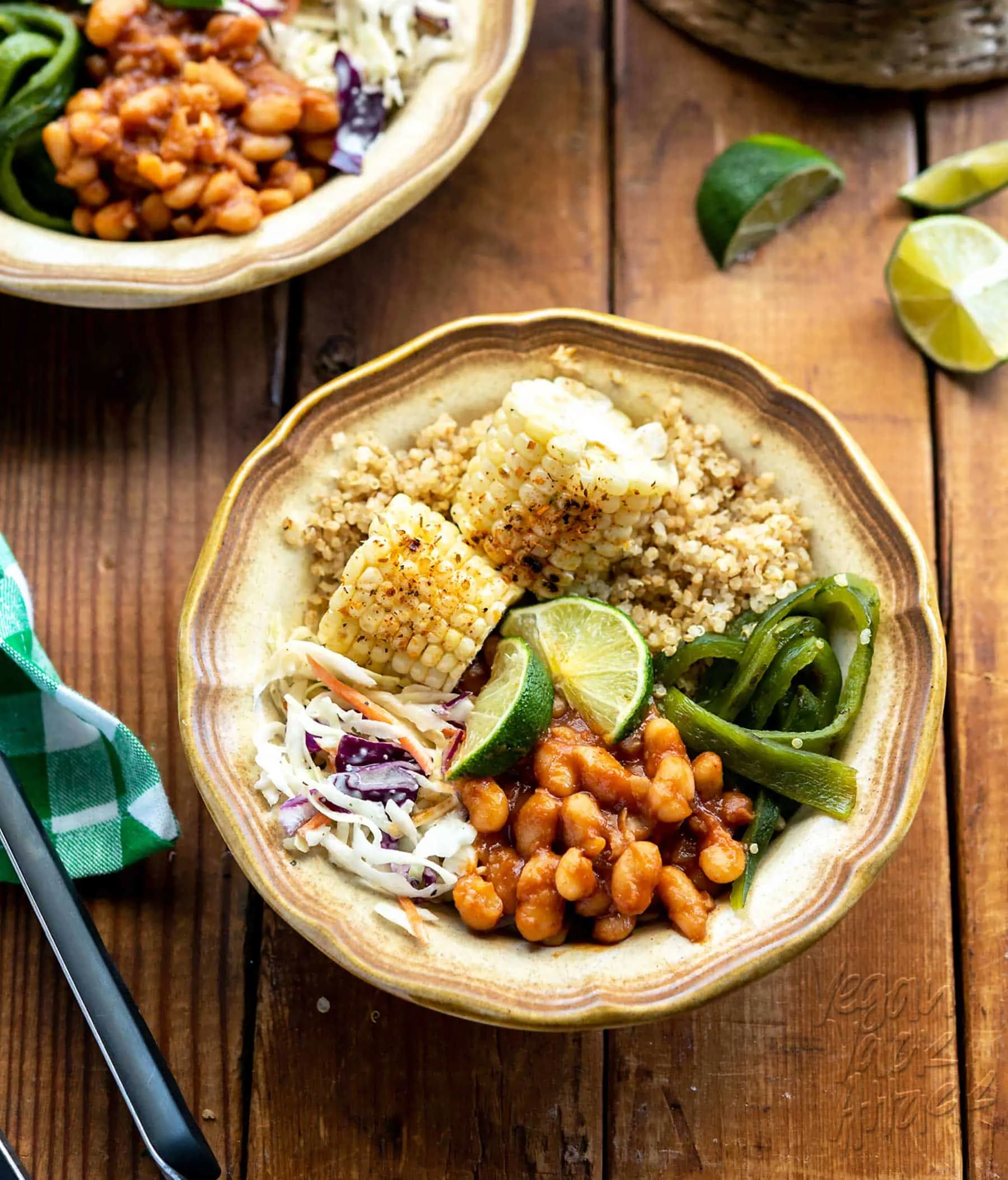 Bowl of summer-time foods including grilled corn, bbq beans, slaw, and quinoa
