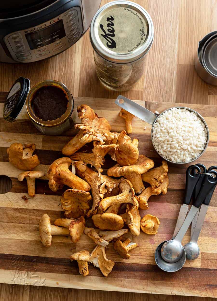 Chanterelle mushrooms with arborio rice on a cutting board.