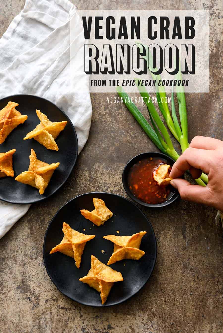 A hand dipping vegan Crab Rangoon into sweet chili sauce, with two black plates of Crab Rangoon, on a napkin and grey background. Text on image reads "Vegan Crab Rangoon from the Epic Vegan Cookbook"