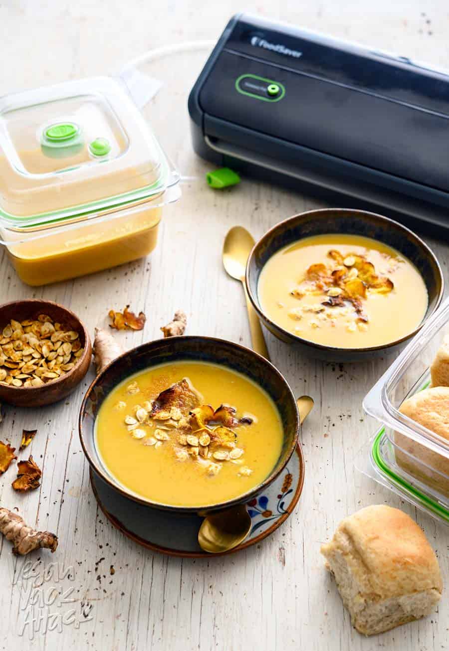 Two bowls of ginger turmeric squash soup with FoodSaver system and containers