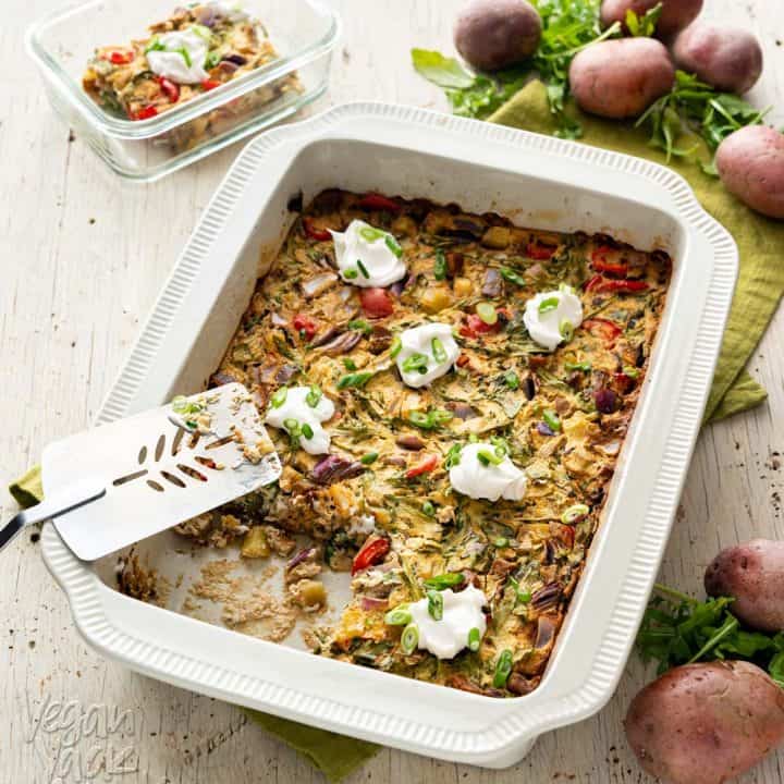 An image of a casserole in a large baking dish, on a wood background with green linen