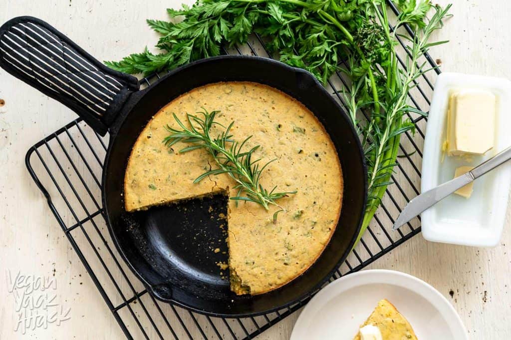 Image of Carrot Top Herb Cornbread on a cooling rack with slice cut out