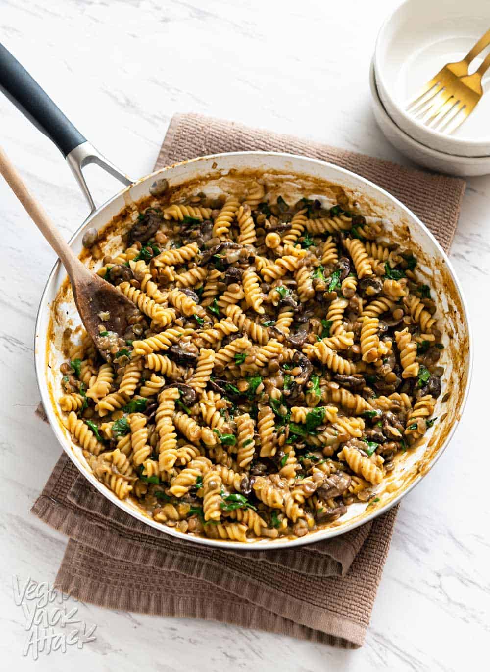 Image of one-pot lentil mushroom pasta in a large pan sitting on a towel