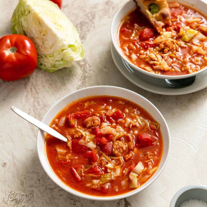 Two bowls of cabbage roll soup on a marble background