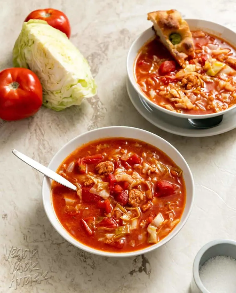 Two bowls of cabbage roll soup on a marble background