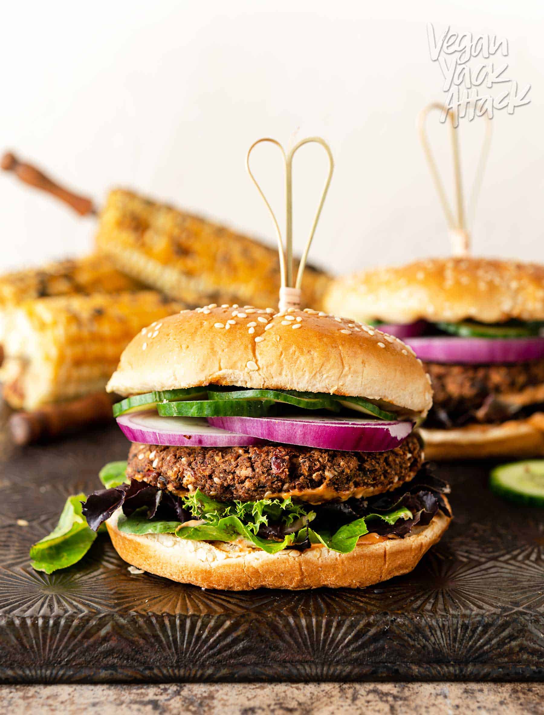Veggie burger stacked with onion, cucumbers, mixed greens and bun