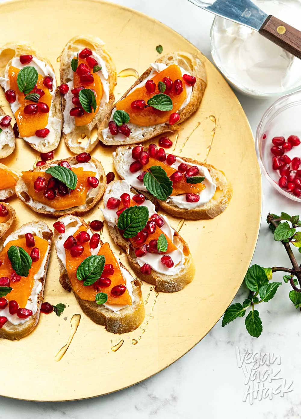 Gold plate topped with pomegranate persimmon crostini