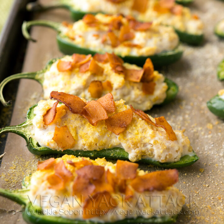 close up of jalapeño poppers on a baking sheet, topped with coconut bacon