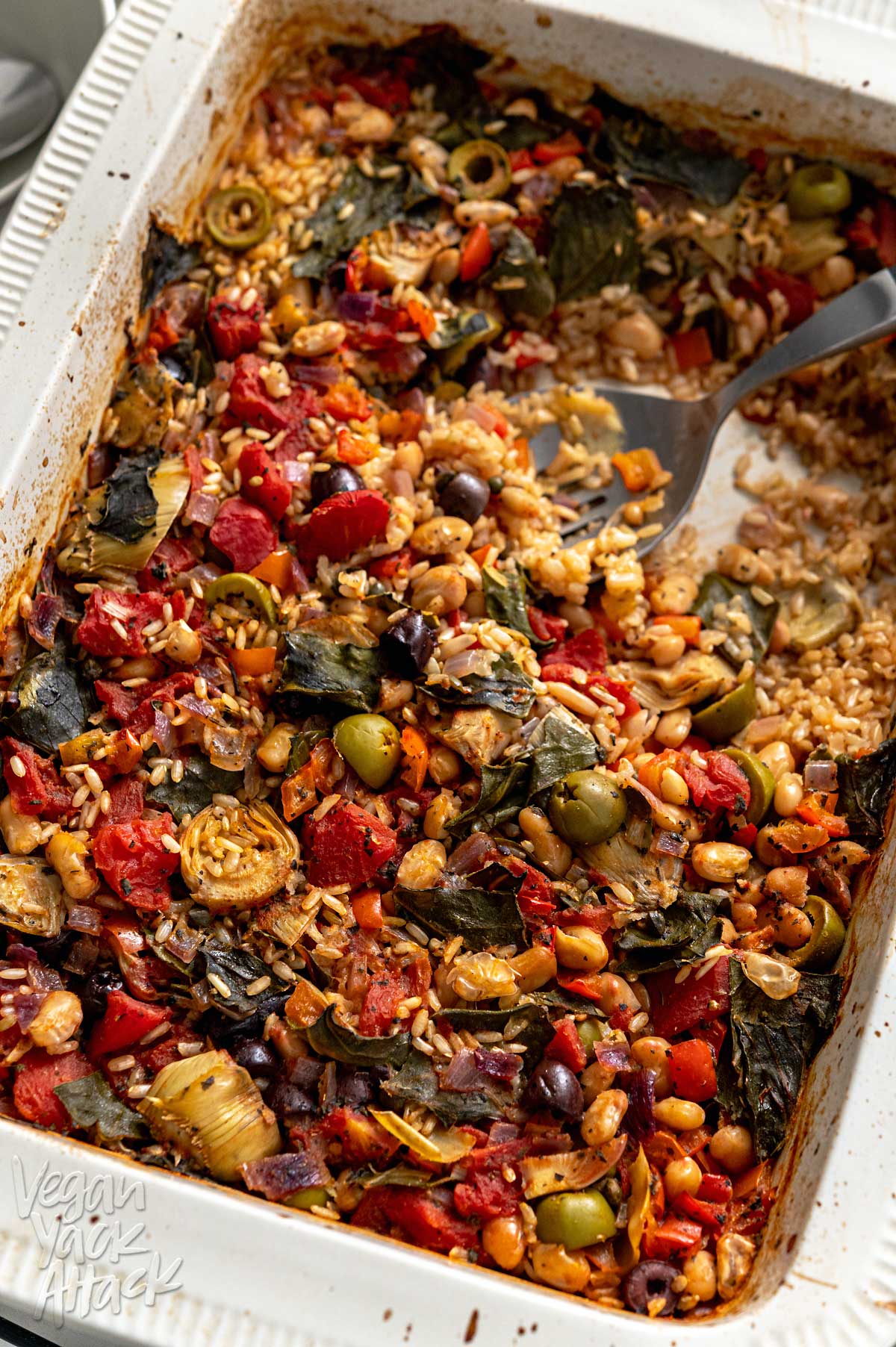 Close up of Large casserole dish containing veggie-filled rice bake on a marble table
