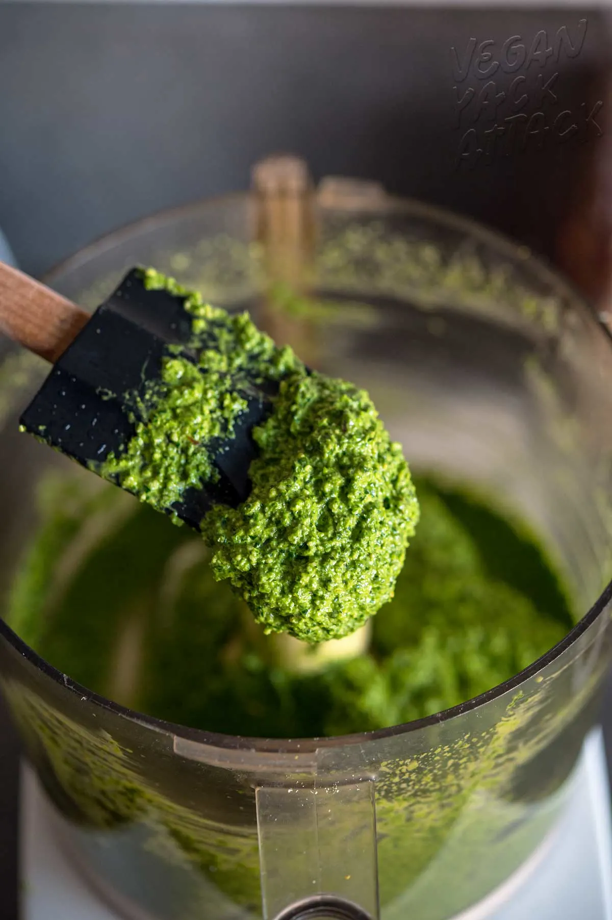 silicone spatula scooping pesto out of food processor