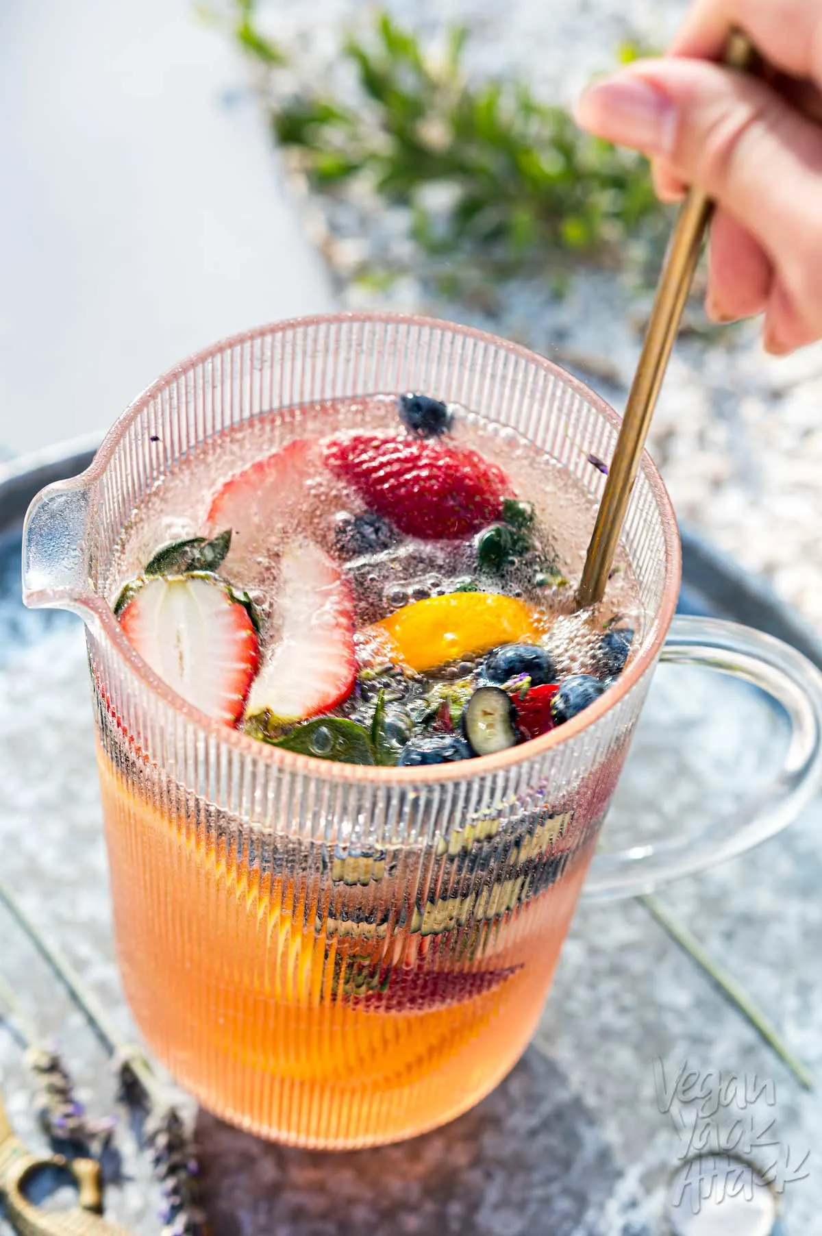 Gold spoon stirring sangria mix in a pitcher