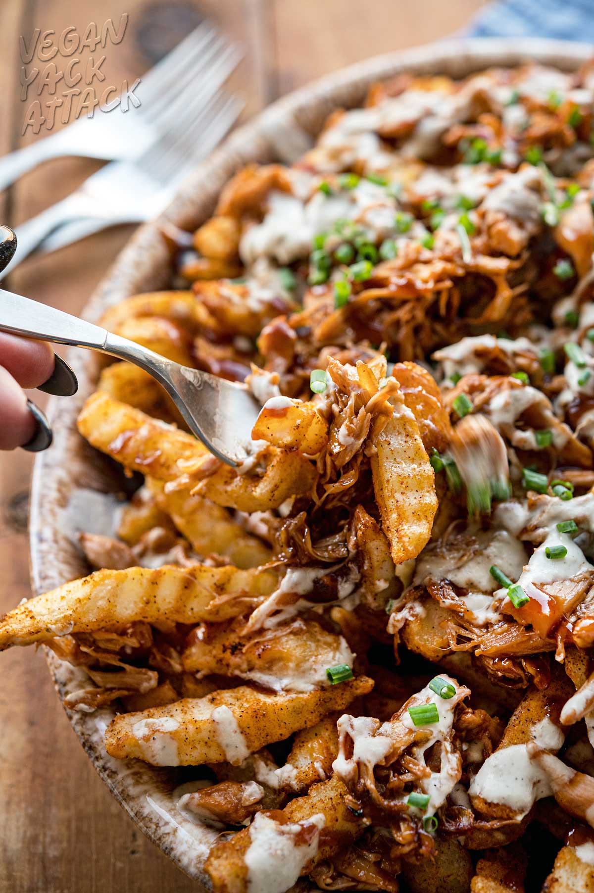 Close up of fork picking up loaded bbq fries