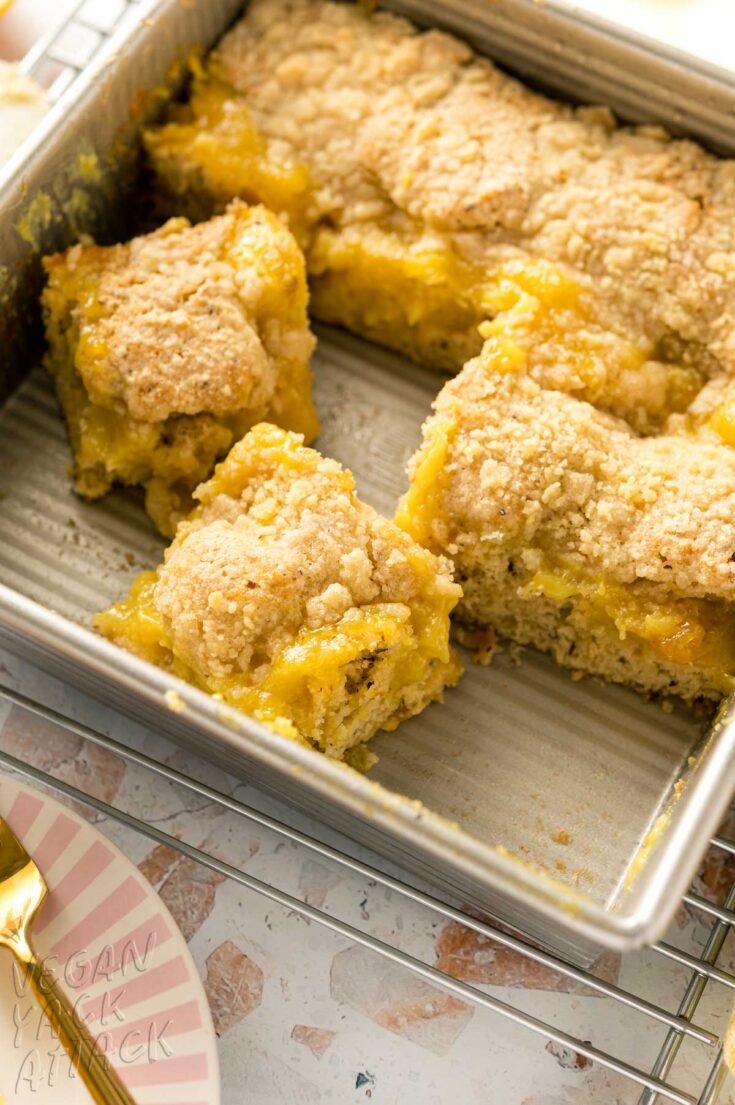 Close up of lemon coffee cake that's been cut into, on a cooling rack